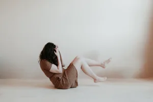 Woman on the floor in brown dress experiencing anxiety attack and or panic attack what does anxiety feel like